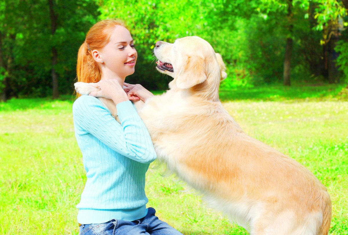 Dog placing paws on owner shoulders
