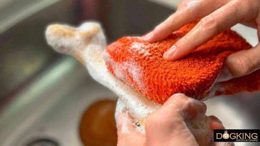 Person washing puppy chew toys